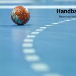 Rot weißer, mit Harz beklebter Handball auf blauem Sporthallenboden