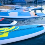 Mehrere am Strand aufgereihte SUPs