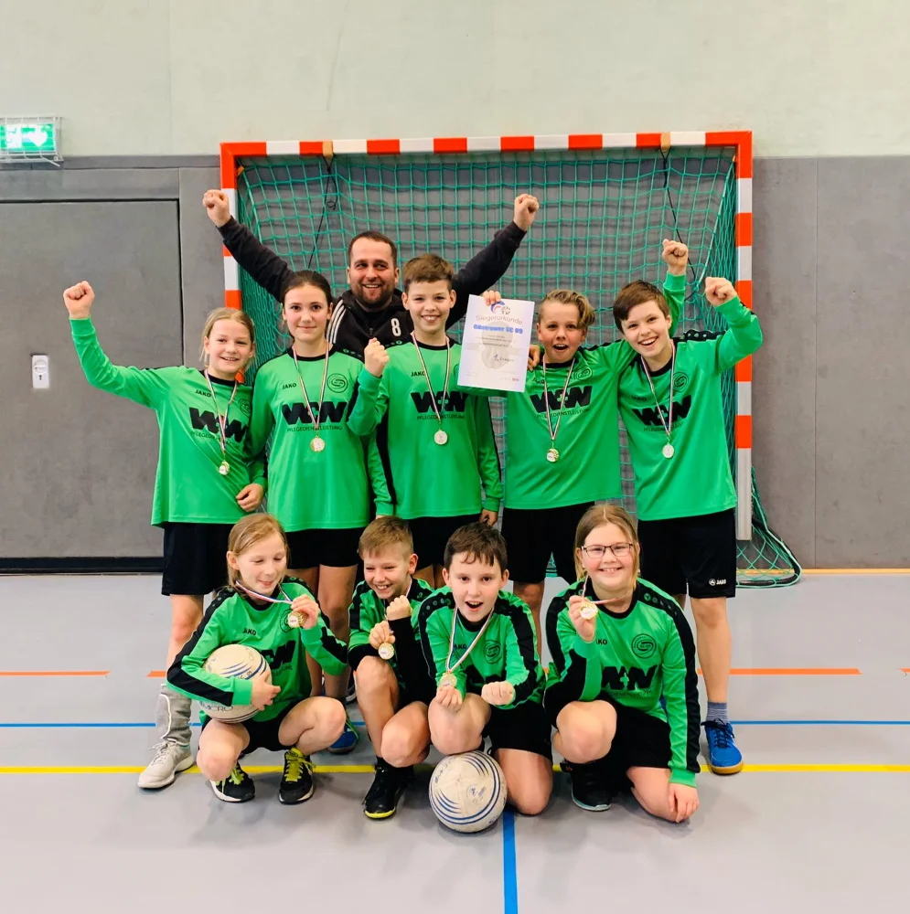Die jubelnden Spieler der U12 nach dem Gewinn der Landesmeisterschaft in Schleswig-Holstein: Hannah Weidemann, Lara Thyben, Toni Freiknecht, Florian Ohloff, Jeppe Tandelmayer, Neele Bieber, Micha Ohloff, Felix Fischer und Amelie Hanke mit ihrem Übungsleiter Philipp Ohloff. Foto: Güstrower SC 09