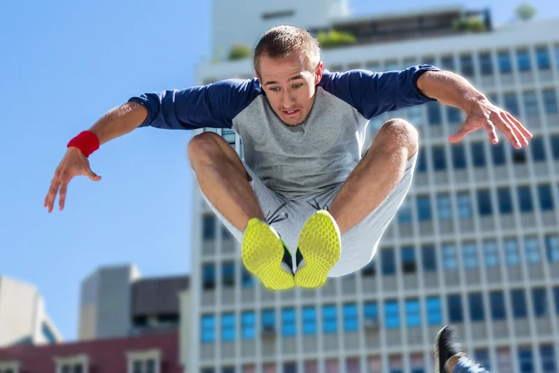 Junger Mann macht in der Stadt an einem sonnigen Tag ein effektives Sprungkrafttraining um seine Sprungkraft zu verbessern |  Stockfoto: envato elements