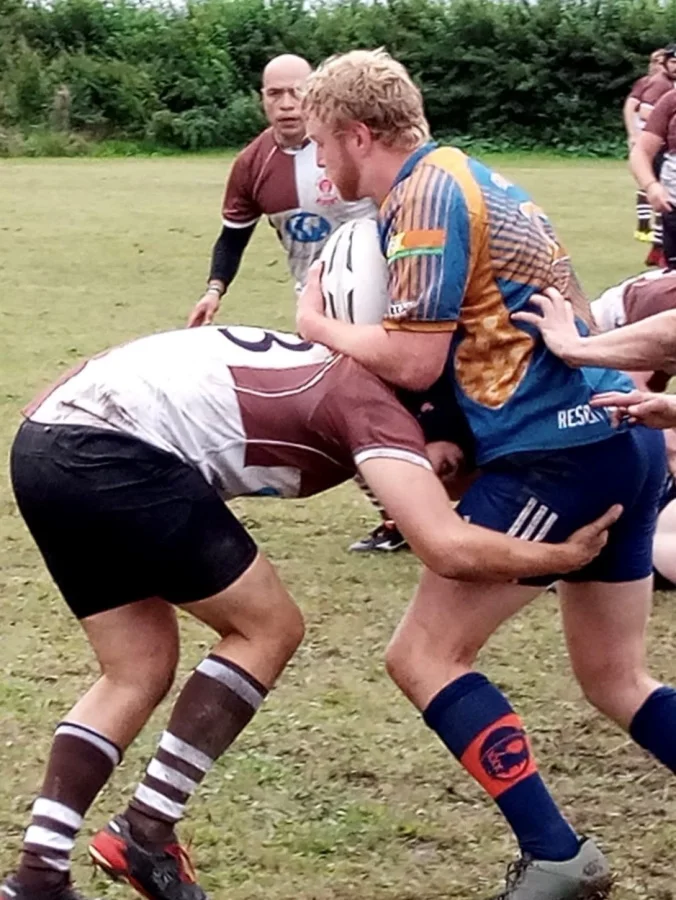Zweite-Reihe-Stürmer Jakob Conradi (mit Ball, blaues Shirt), der von einem Gegenspieler von St. Pauli gestoppt wird (Tackling). Foto: Alex Bellin