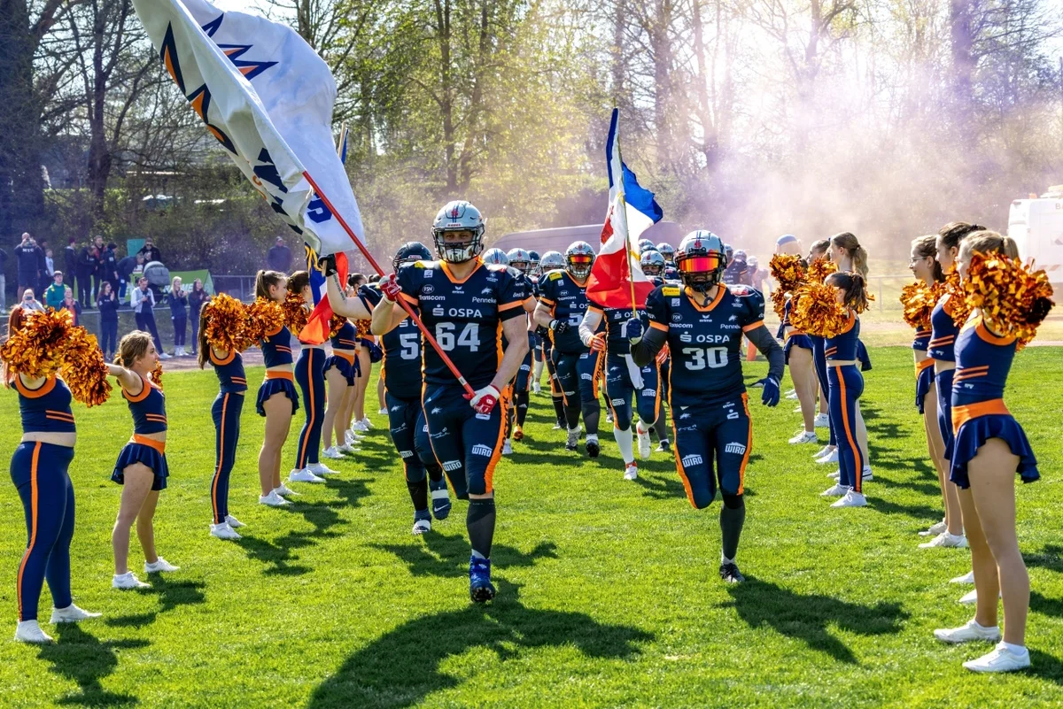 Einlauf der Rostock Griffins auf das Spielfeld, bejubelt von den eine Gasse bildenden Cheerleaderinnen.