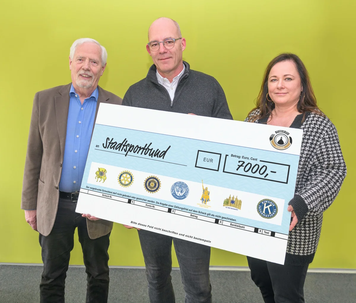 Wulf Kawan (l.) und Babette Herrmann (r.) vom Organisationsteam des Martensmann-Festschmauses überreichten die Spende für Kinder und Jugendliche an Dirk Pollakowski (m.) vom Stadtsportbund Schwerin. (Foto: maxpress/Ingo Wziontek)