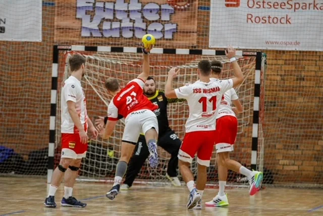 Warnemünder Handballer springt hoch um den Ball auf das Tor zu werfen.