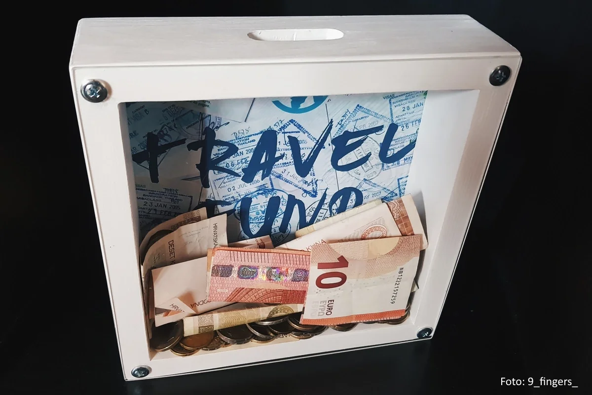 verglaste Spendenbox mit mehreren Euro-Banknoten und Münzen