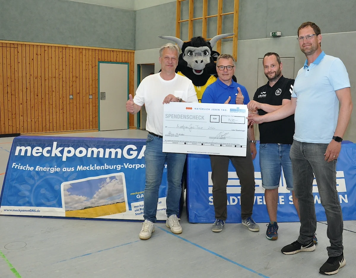 Axel Schulz (l.) und Aurel Witt (r.) von den Schweriner Stadtwerken übergeben eine Spende für den VfL BW Neukloster an Andree Kopitzke (2.v.l.) und Ole Steinhagen. (Foto: Barbara Arndt)