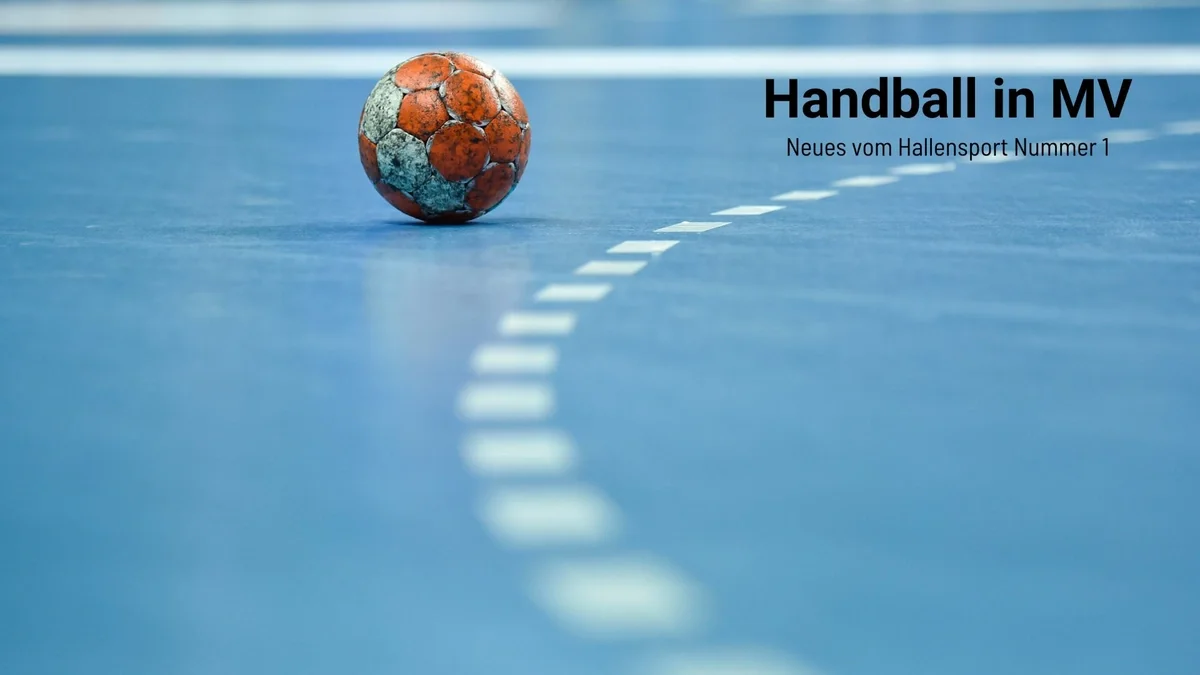 Rot weißer, mit Harz beklebter Handball auf blauem Sporthallenboden