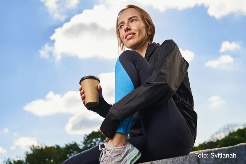 Symbolbild freundliche Sportlerin mit einer Tasse Kaffee im Freien nach dem Sport - Copyright Svitlanah Symbolbild freundliche Sportlerin mit einer Tasse Kaffee im Freien nach dem Sport - Foto Svitlanah