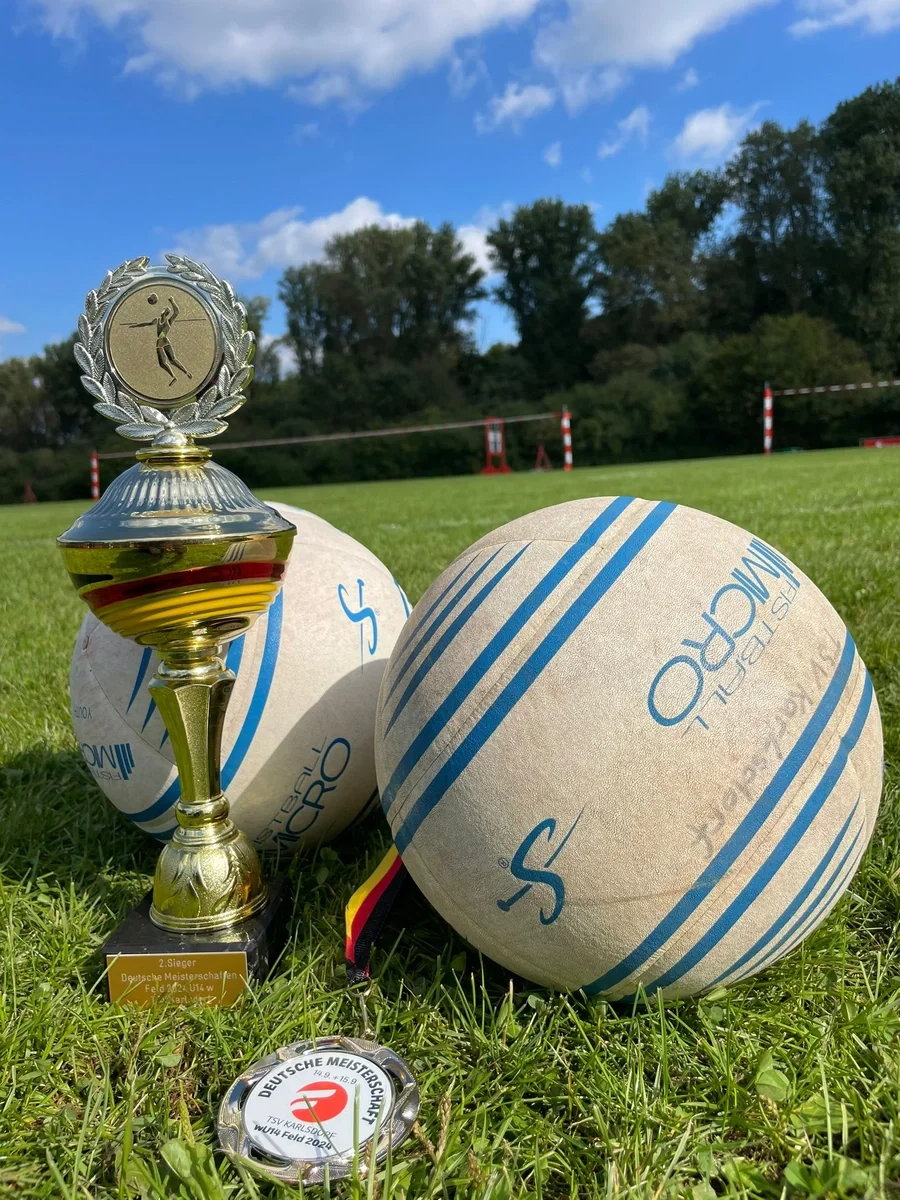 © ESV Schwerin Zwei Fausbälle liegen neben einm Pokal im Gras