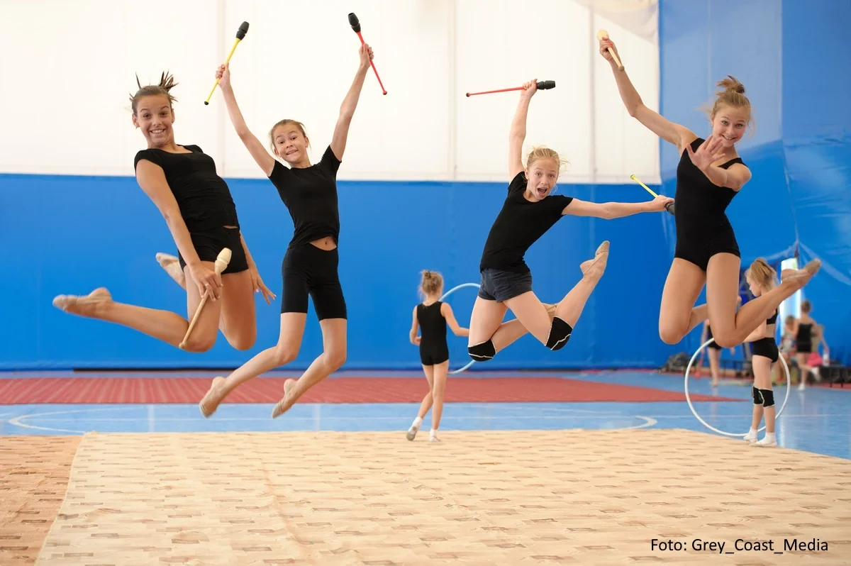 Junge Gymnastinnen springen freudig in die Luft