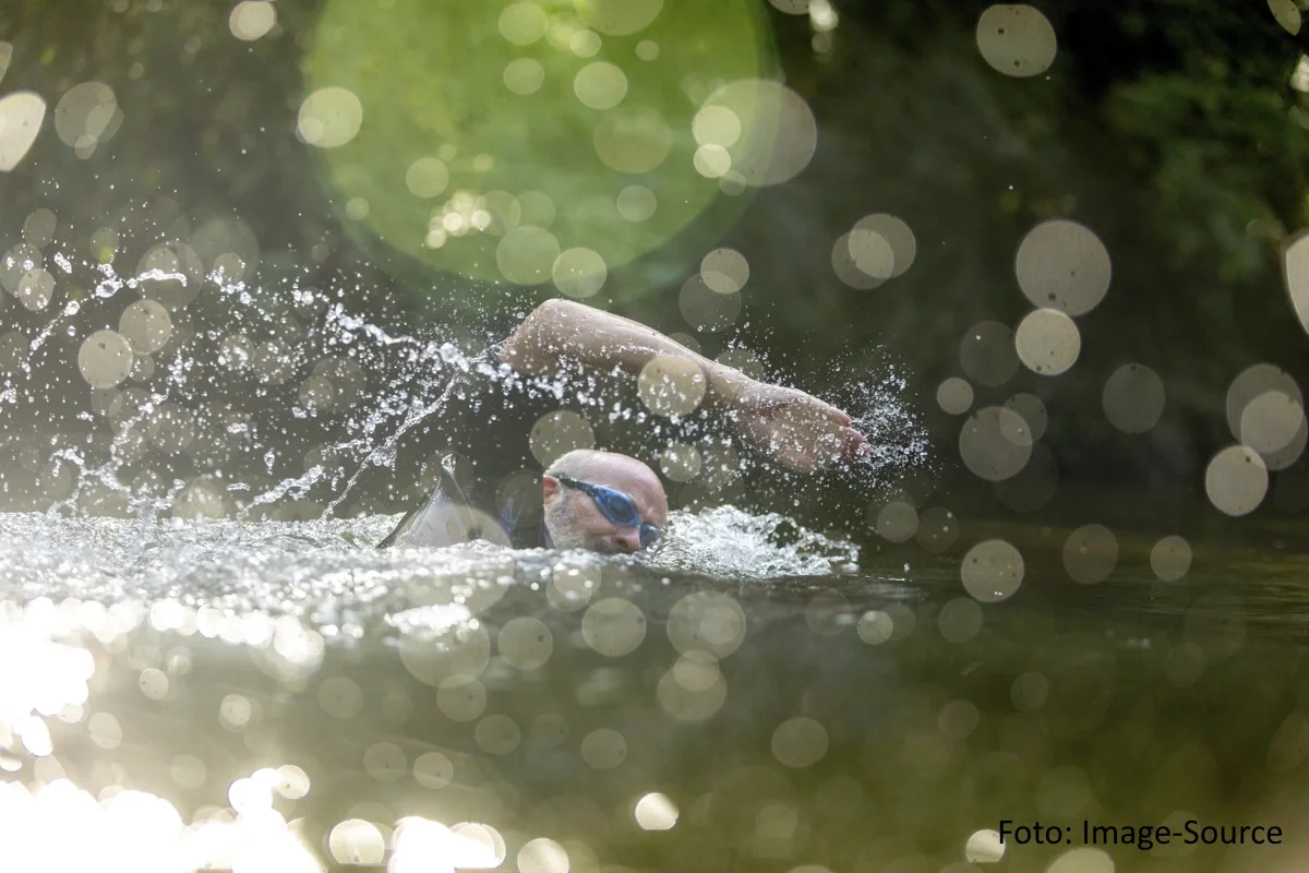 Freiwasserschwimmer in kulrzärmligem Neoprenanzug und Schwimmbrille im Freistil