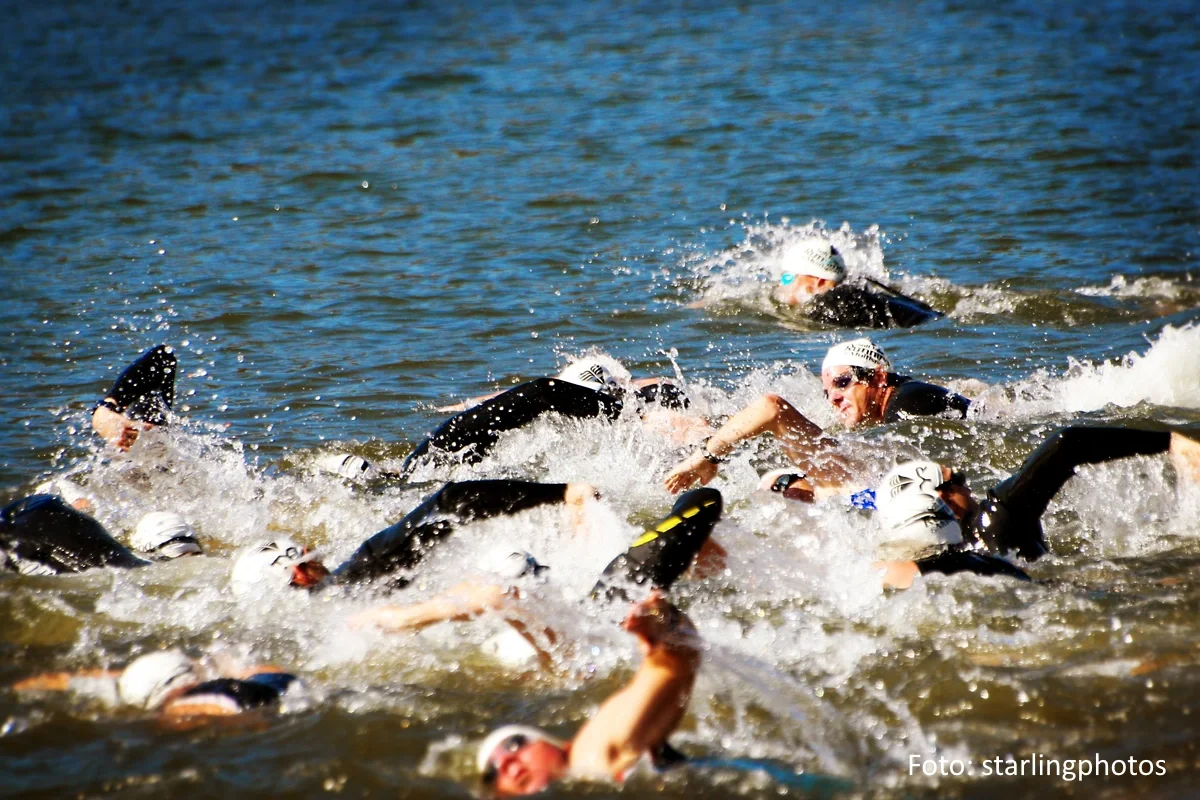 Eine Ansammlung männlicher Freiwasserschwimmer während eines Triathlon Wettbewerbs.