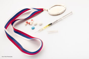 A set of a winner with a syringe, doping pills and a gold prize medal.