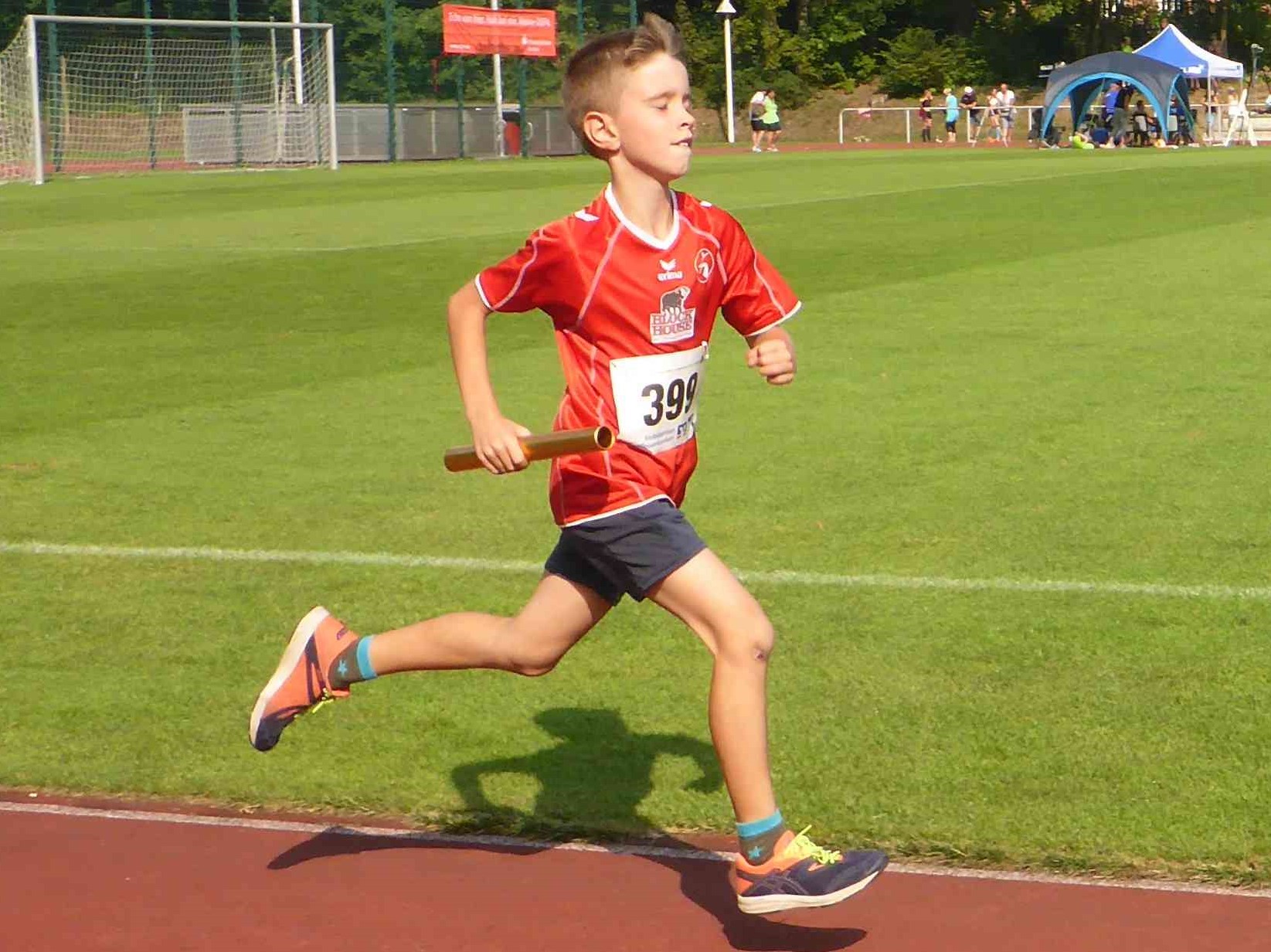 Das Foto zeigt einen Laager Jungen beim Staffellauf - noch ohne Spikes.