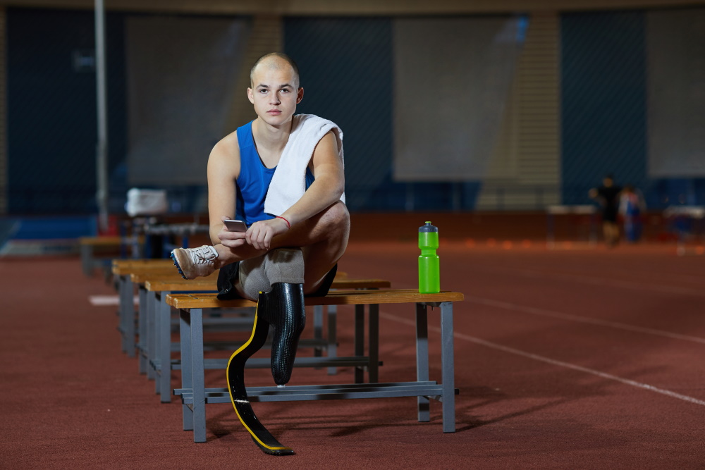 Paralympischer Sportler mit Beinprothese sitzt auf einer Bank (Foto: envato elements)