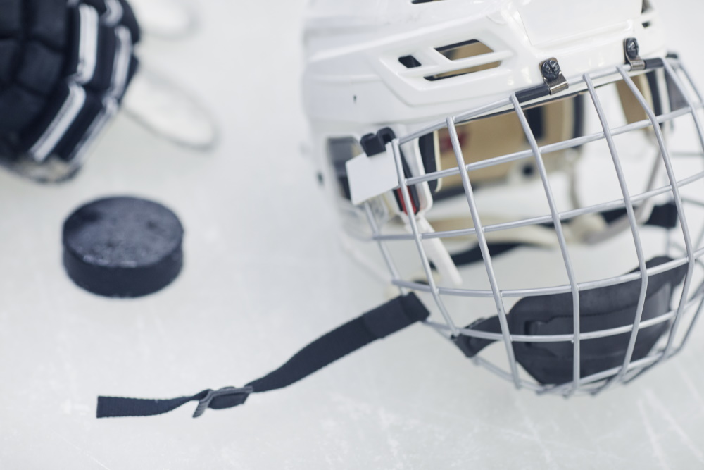 Eishockey: Helm und Puck auf Eisfläche