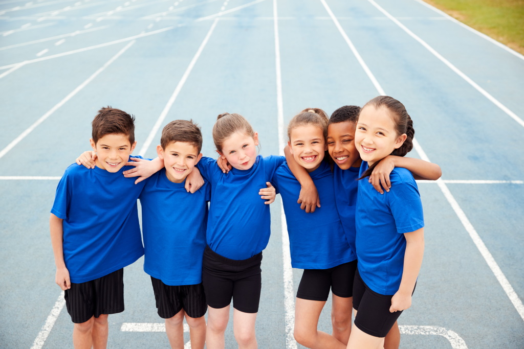 Porträt von Kindern in Leichtathletik Team auf der Strecke am Sport Tag