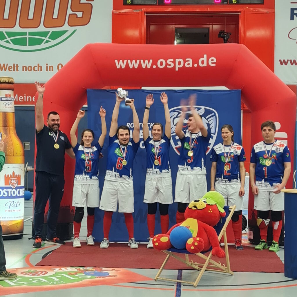 Mannschaftsbild des Rostocker Goalballclubs. Team und Trainer bejubeln im Siegestaumel ihren Erfolg nach dem Finale in der Rostocker OSPA Arena