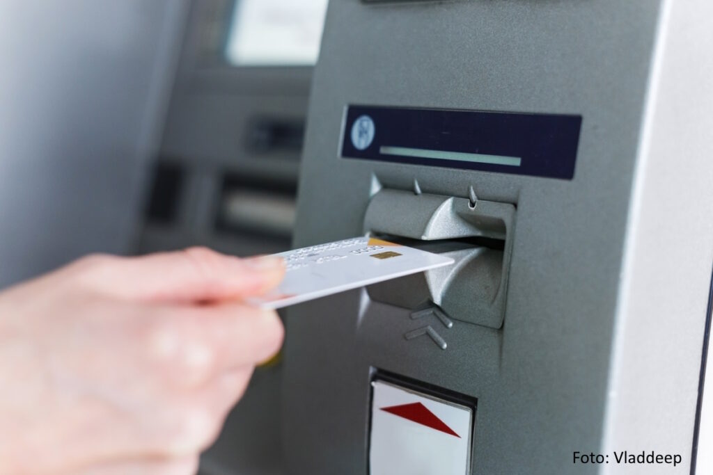 Person steckt eine Karte in den Geldautomaten