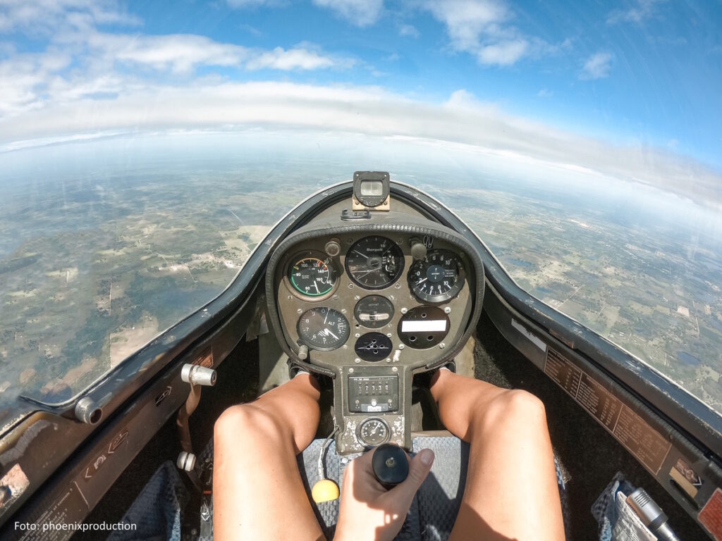 PoV - Blick auf die Erde aus dem Cockpit eines Segelflugzeugs.