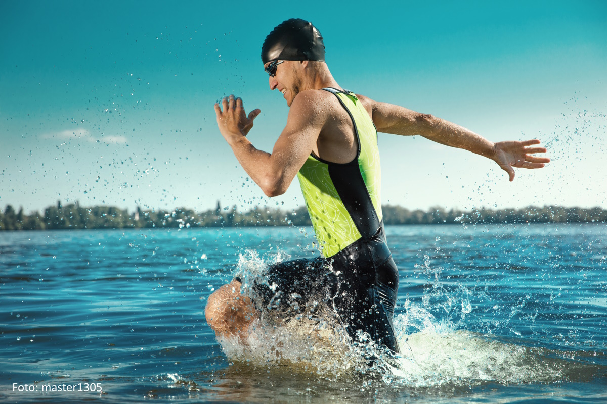 Professioneller Triathlet läuft ins Wasser