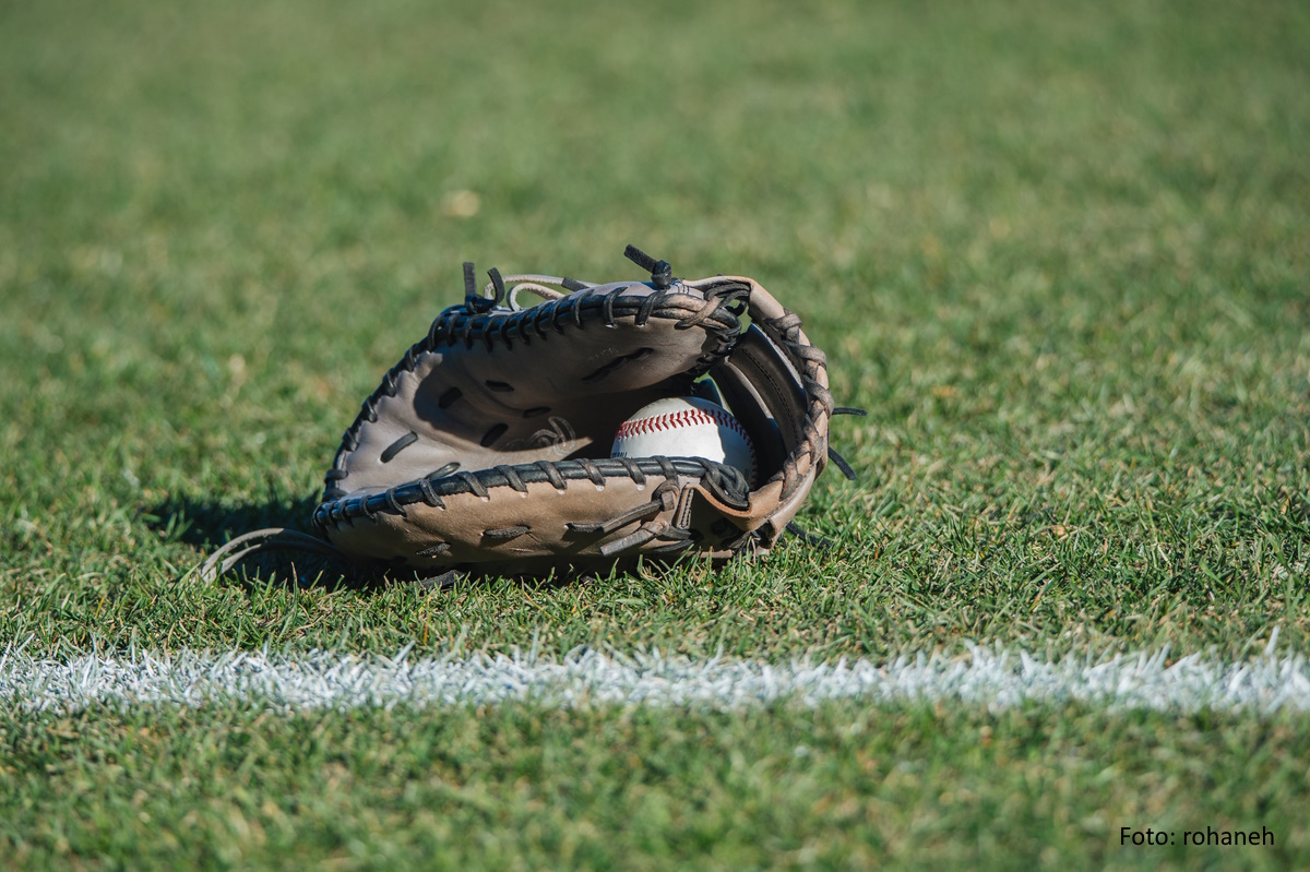 Baseballhandschuh mit Ball auf grünem Rasen