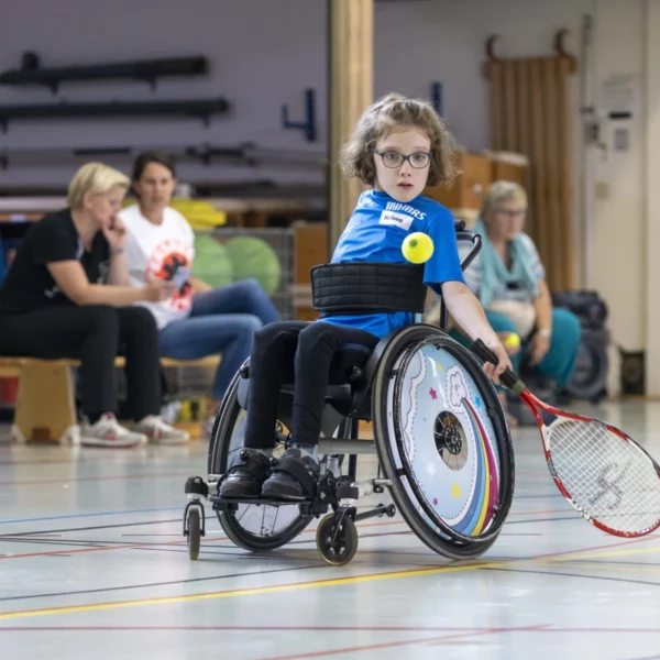 Tennis spielendes Mädchen im Rollstuhl