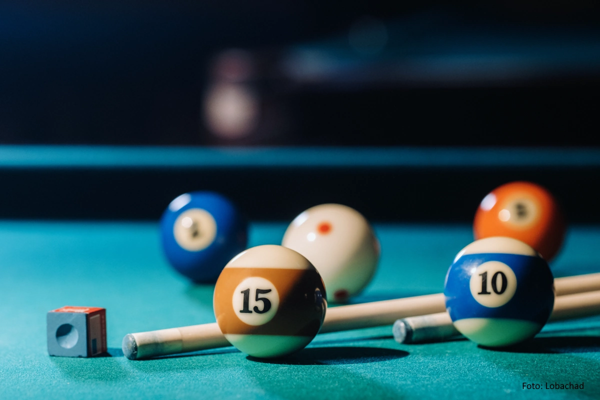Pool-Billard Kugeln auf einem tĂŒrkis schimmerndem Billardtisch