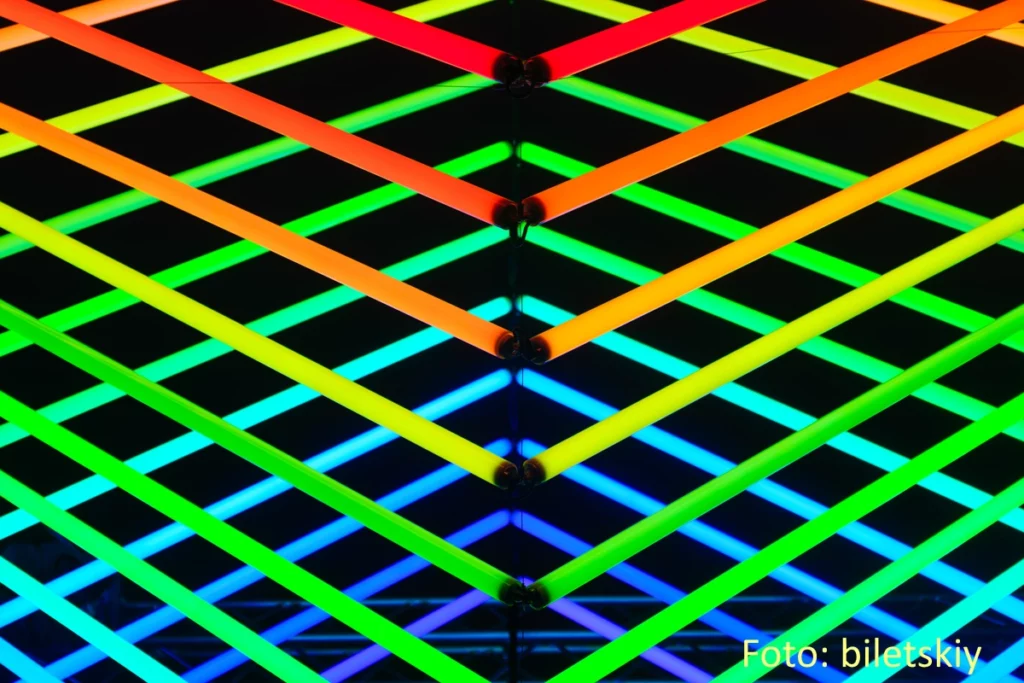 neonfarbene Leuchtstoffröhren in verschiedenen Farbtönen bilden ein Gittermuster