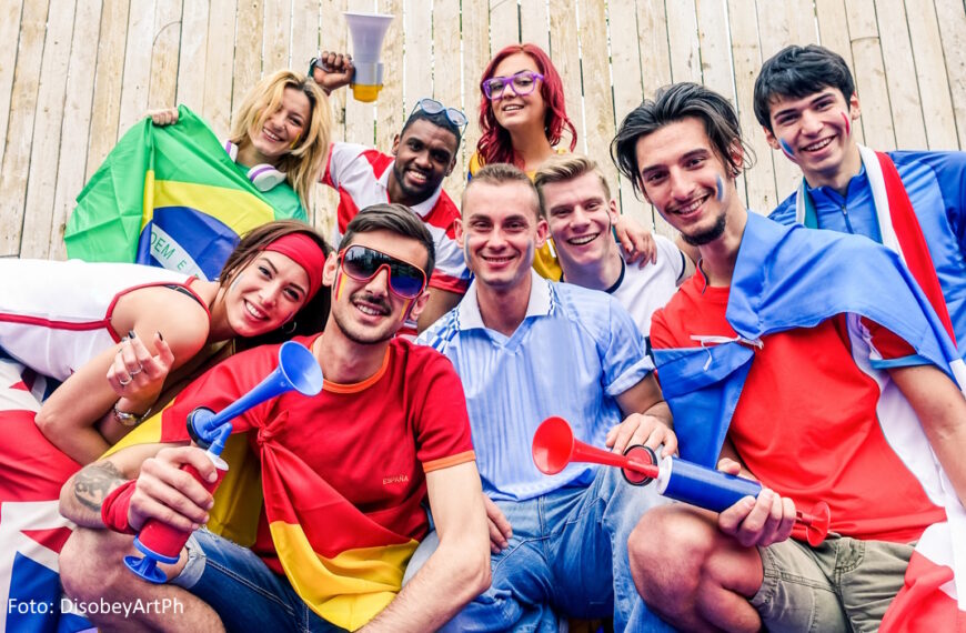 Eine Gruppe junger Leute aus unterschiedlichen Nationen feiert ein Sportevent.