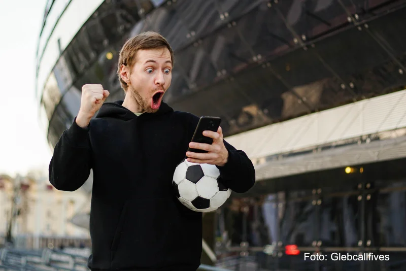 Preiswahnsinn Fußballtickets - Symbolbild Fussballfan kauft günstig Fussballticket online über Handy - Foto Glebcallfives