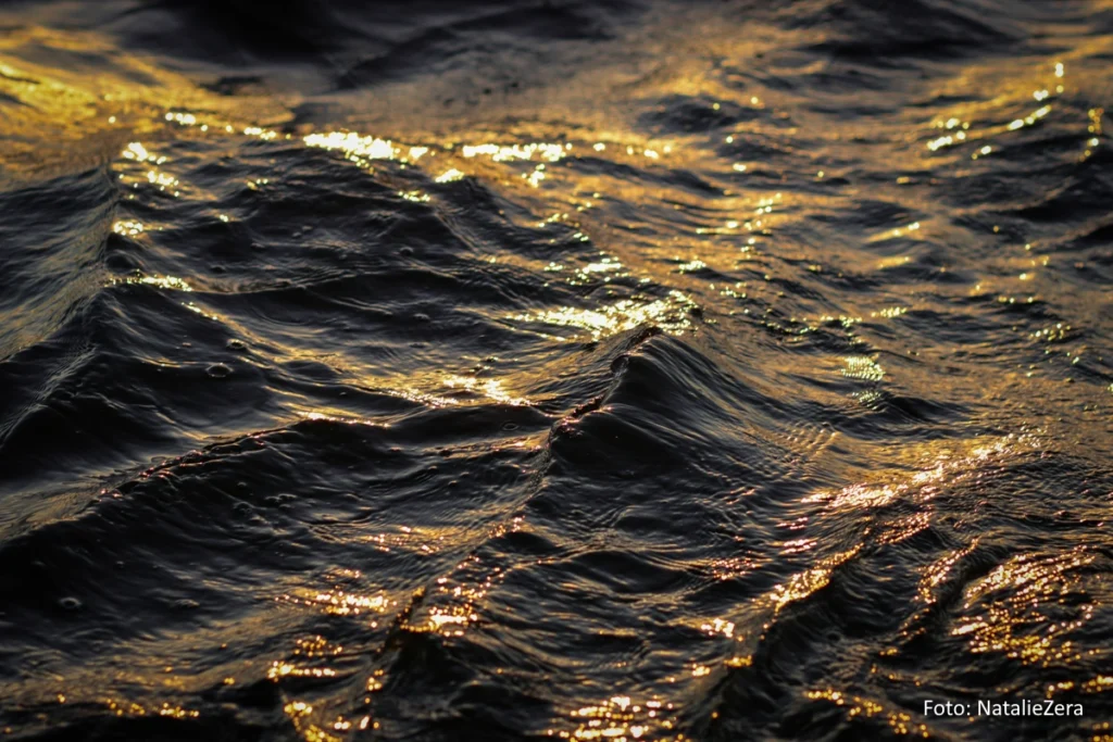 leichter Wellengang auf der Wasseroberfläche eines Sees im Abendlicht