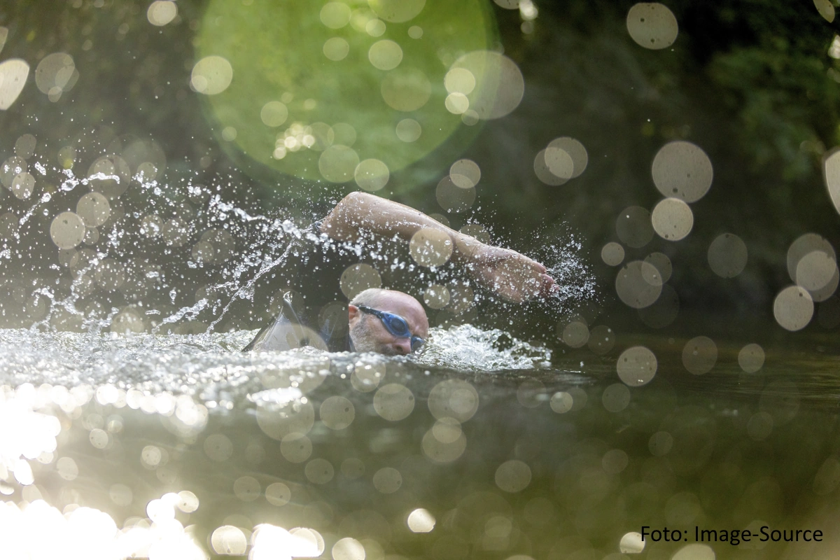 Freiwasserschwimmer in kulrzärmligem Neoprenanzug und Schwimmbrille im Freistil